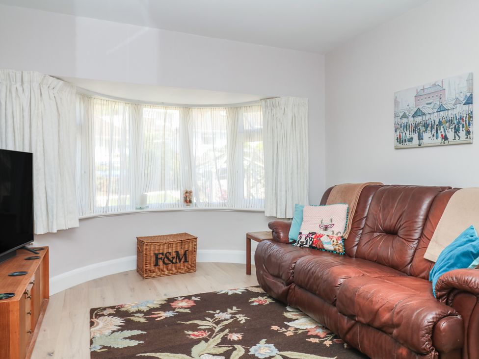 A living room with a sofa and a television at 3 Heath Park in Brixham