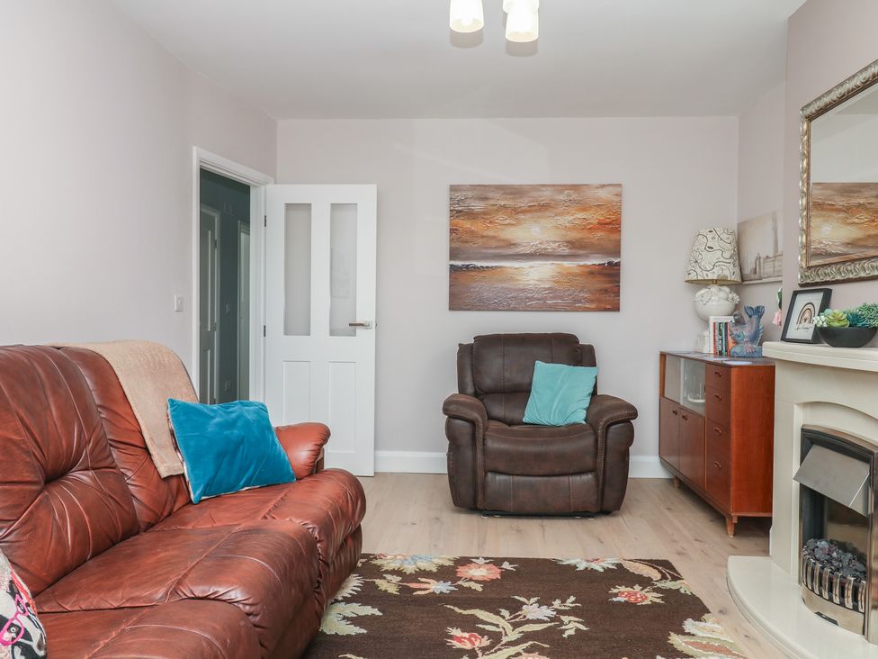A living room with a sofa and armchair at 3 Heath Park in Brixham
