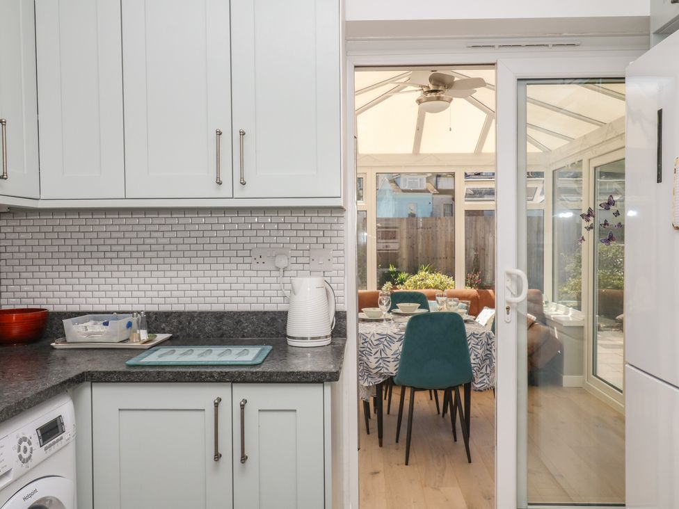 A kitchen with countertop and appliances leading to a dining area at 3 Heath Park Brixham