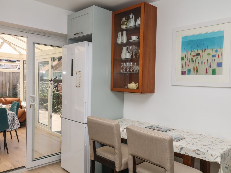 A kitchen featuring a refrigerator, table and bar stools at 3 Heath Park Brixham