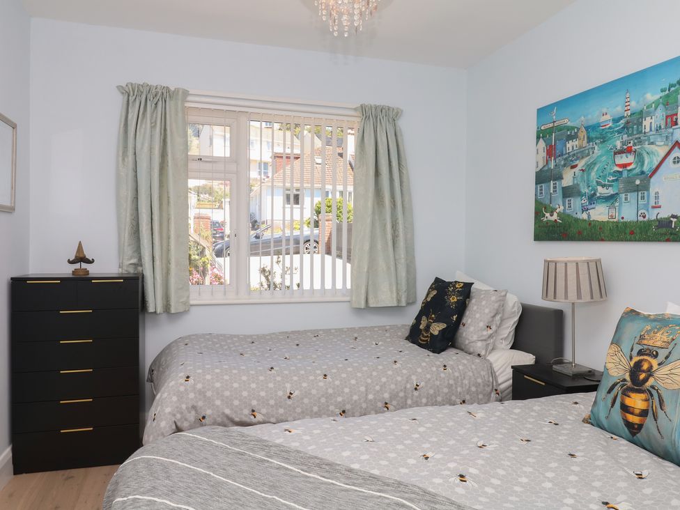 A bedroom with two beds and a window at 3 Heath Park in Brixham