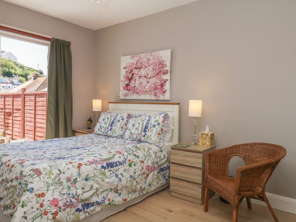 A bedroom with a bed, nightstand, lamp, and chair at 3 Heath Park in Brixham