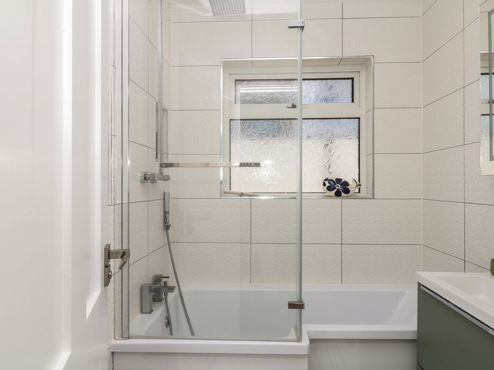 A bathroom with a bathtub and shower at 3 Heath Park, Brixham