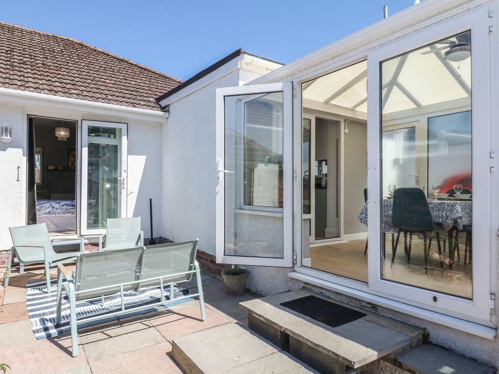 An outdoor area with chairs and a table at 3 Heath Park in Brixham