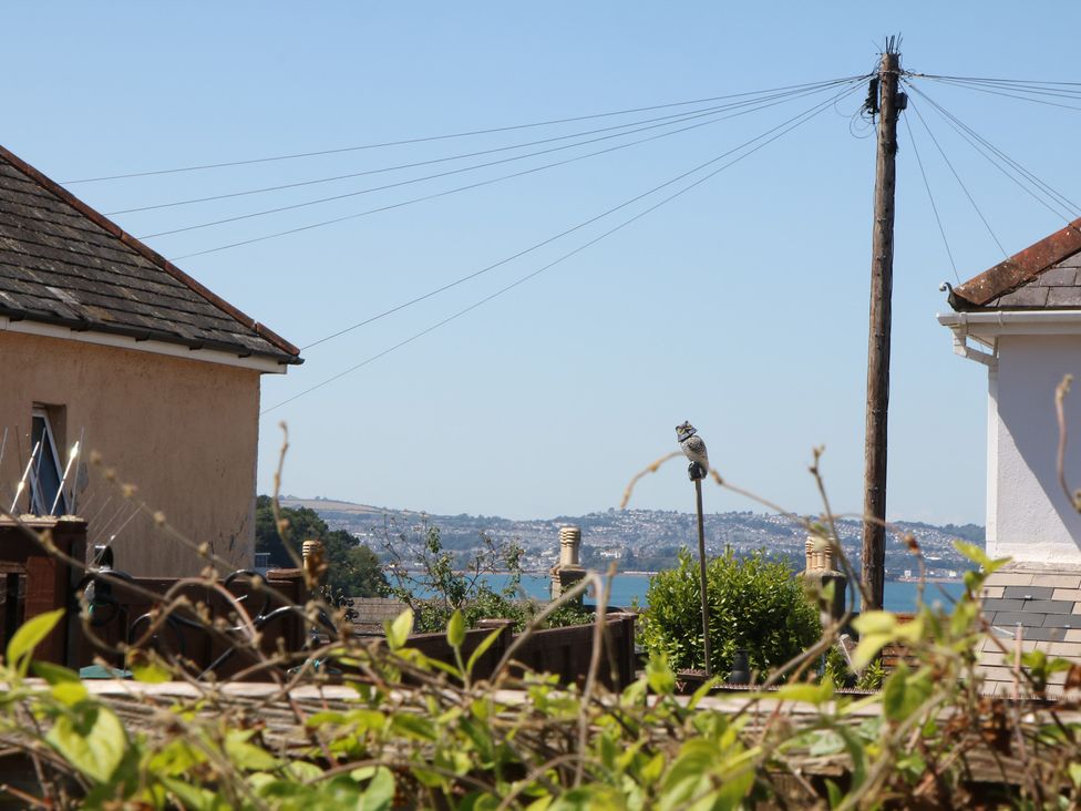 A view of houses and water from a garden at 3 Heath Park Brixham