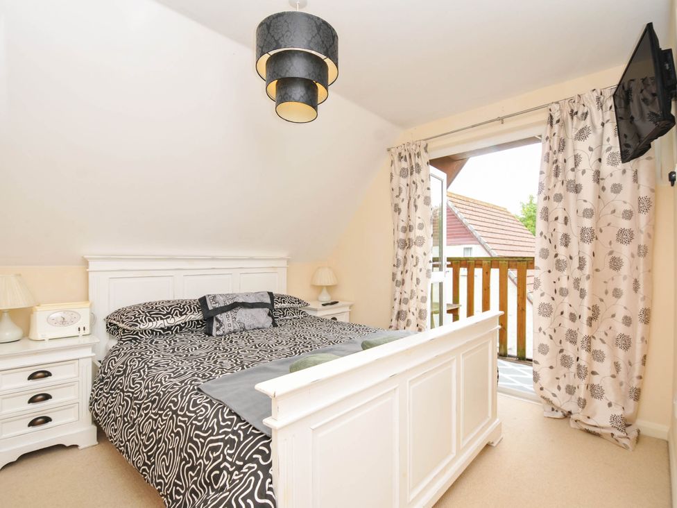 A bedroom with a bed and balcony at No.122 Hengar Holiday Park near St Tudy