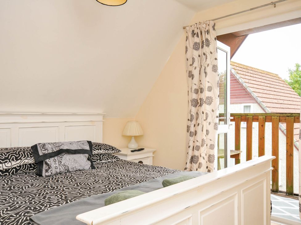 A bedroom with a bed and balcony at No.122 Hengar Holiday Park near St Tudy