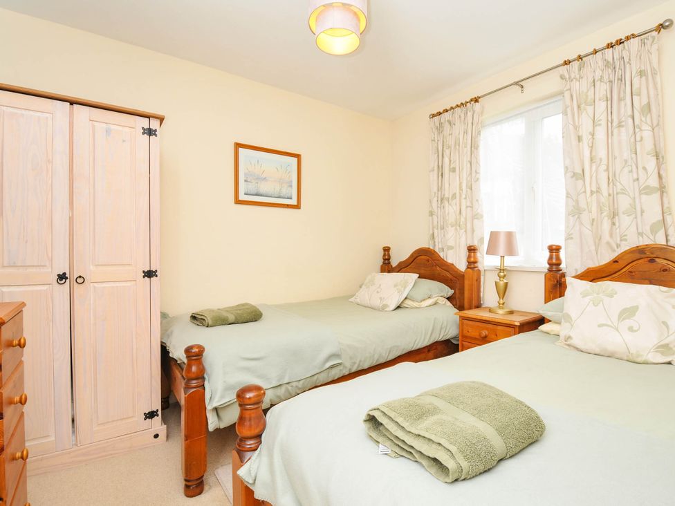 A bedroom with two beds and a wardrobe at No.122 Hengar Holiday Park near St Tudy