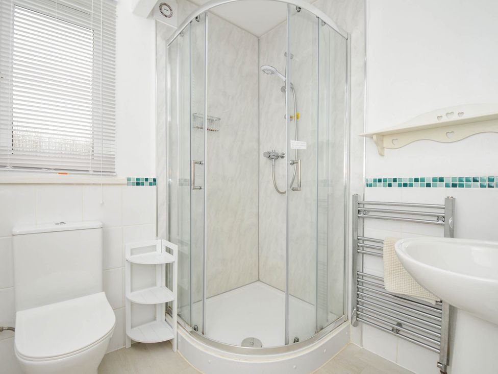 A bathroom with a shower, toilet, and sink at No.122 Hengar Holiday Park near St Tudy