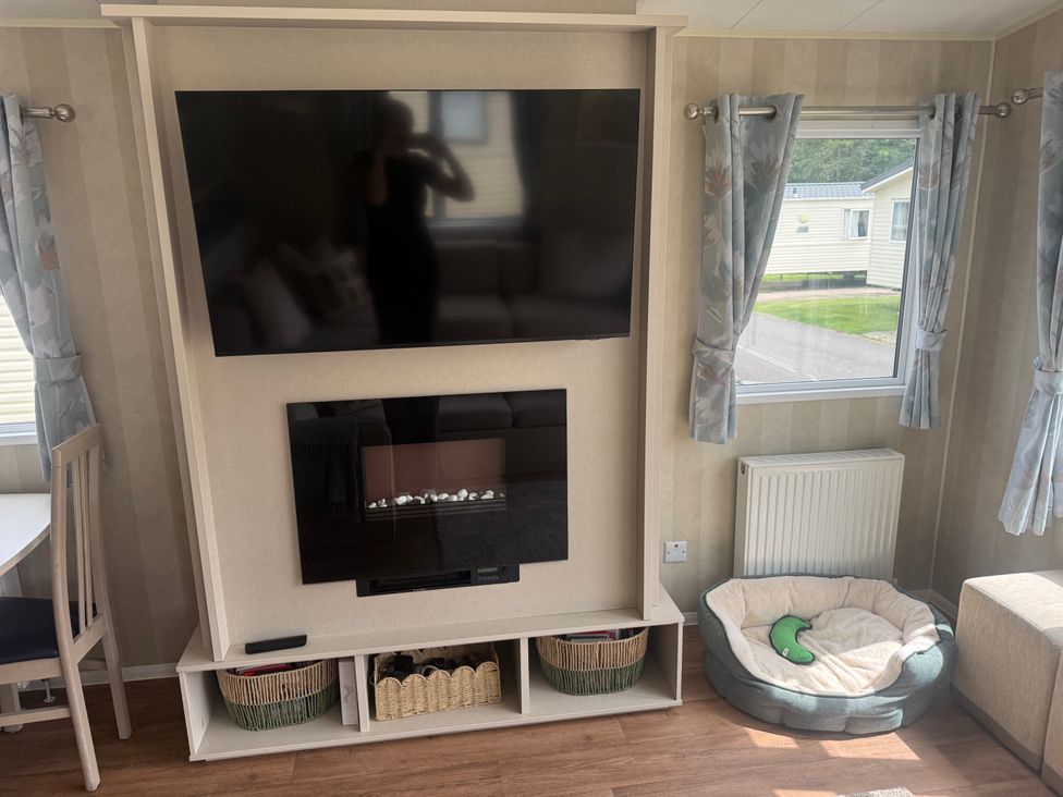A living room with television and seating area at Haggerston Castle Lakeside East 76 in Berwick-upon-Tweed