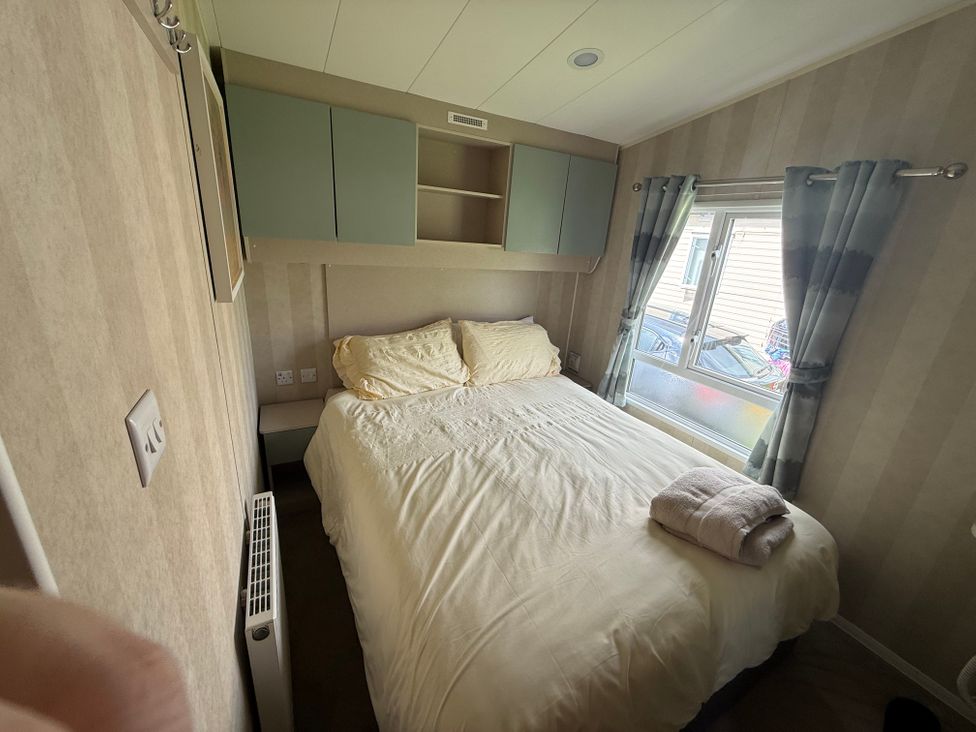 A bedroom with a bed and window at Haggerston Castle Lakeside East 76 Berwick-upon-Tweed
