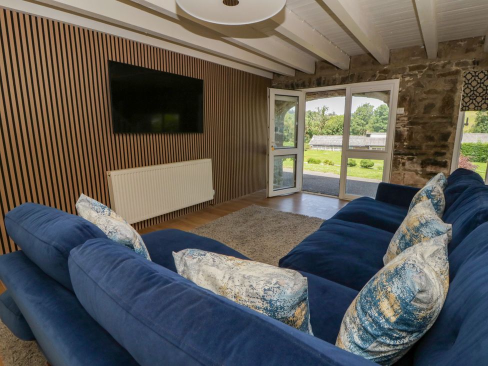 A living room with a sofa and television at The Cart House in Pontsian