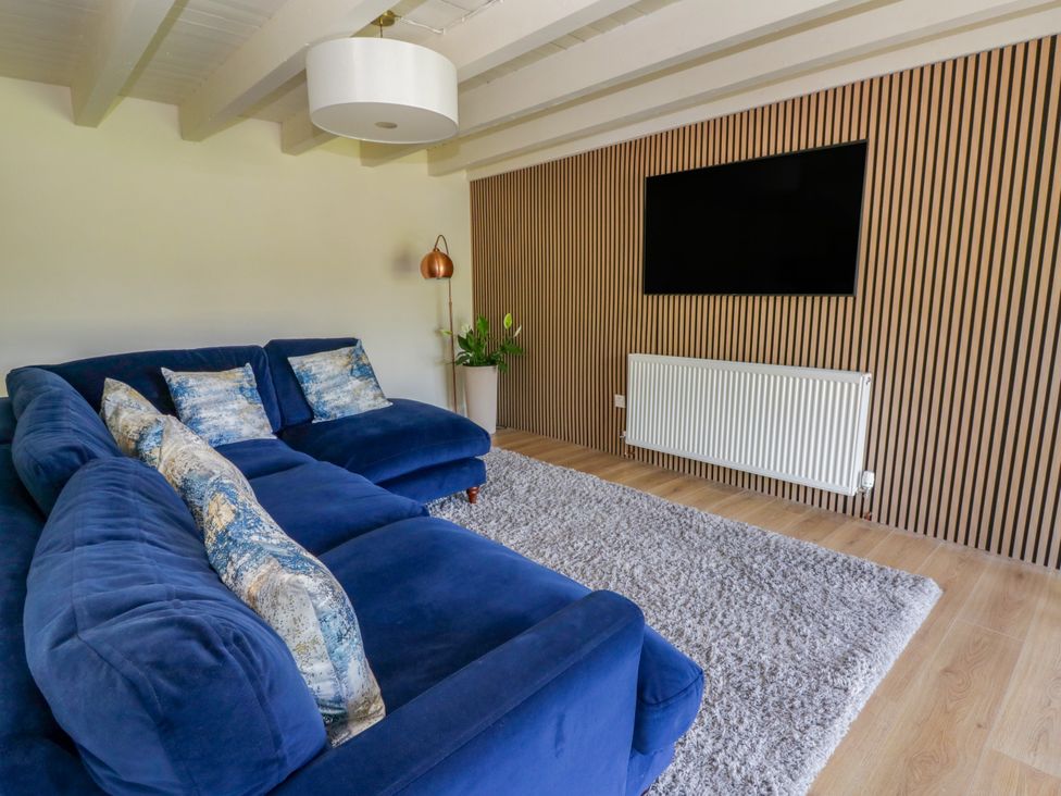 A living room with a sofa and television at The Cart House in Pontsian