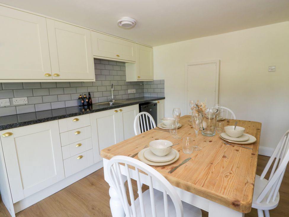 A kitchen with a table set for dining at The Cart House in Pontsian