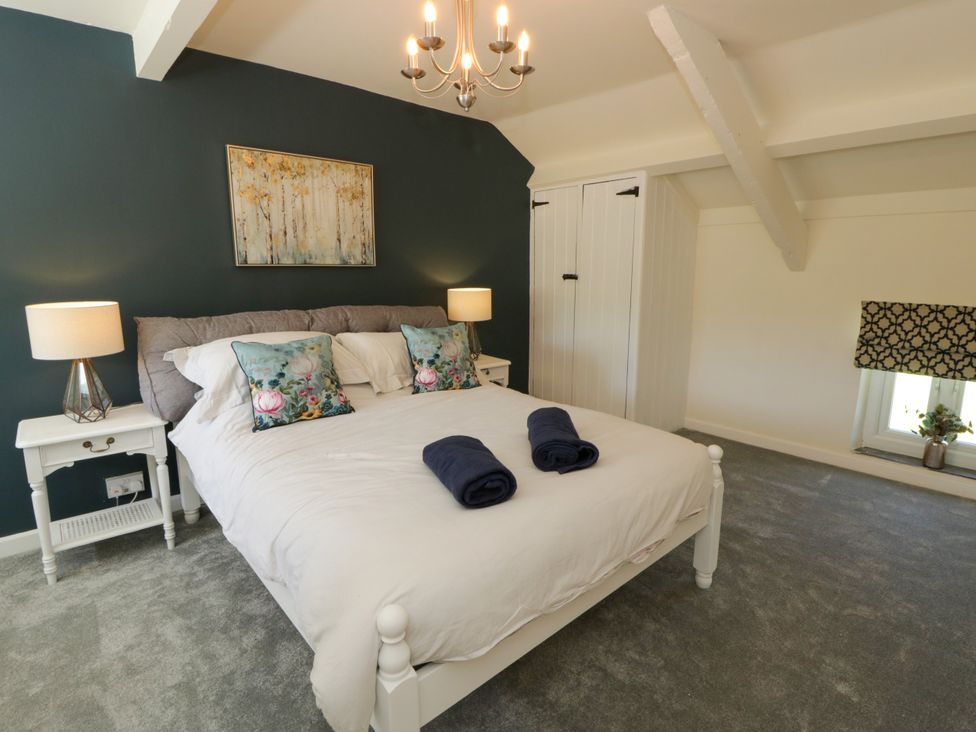 A bedroom with a bed and nightstands at The Cart House in Pontsian