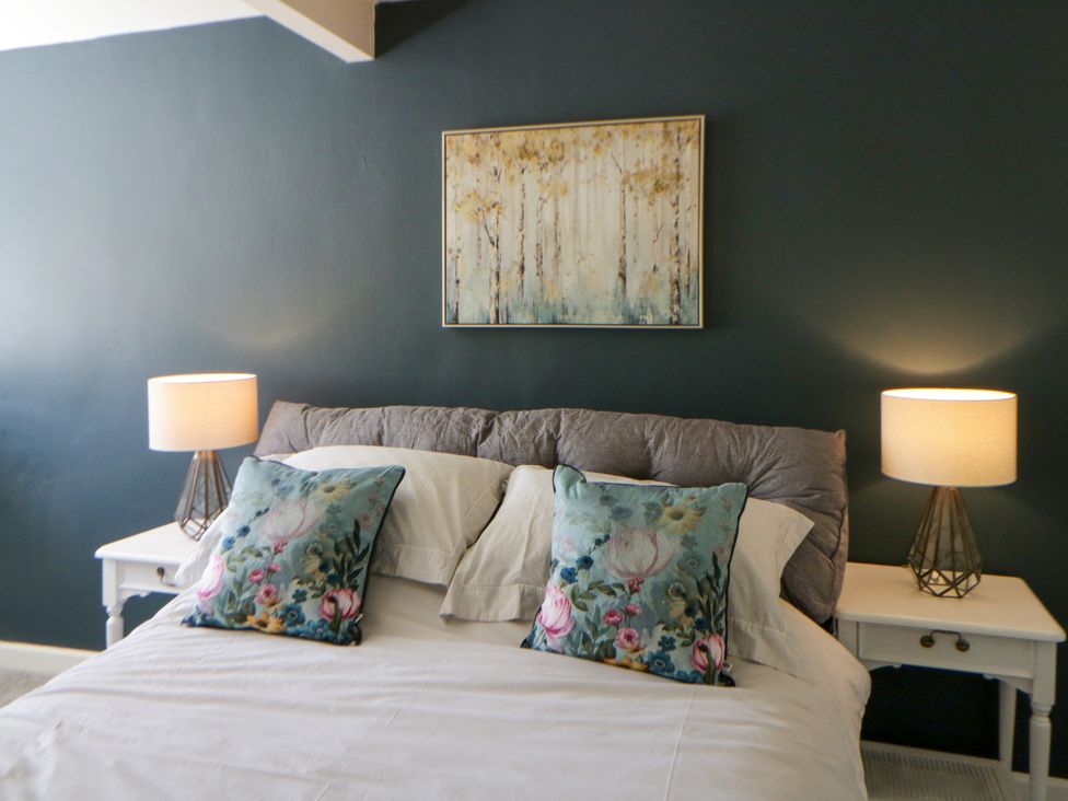 A bedroom with a bed and nightstands at The Cart House in Pontsian