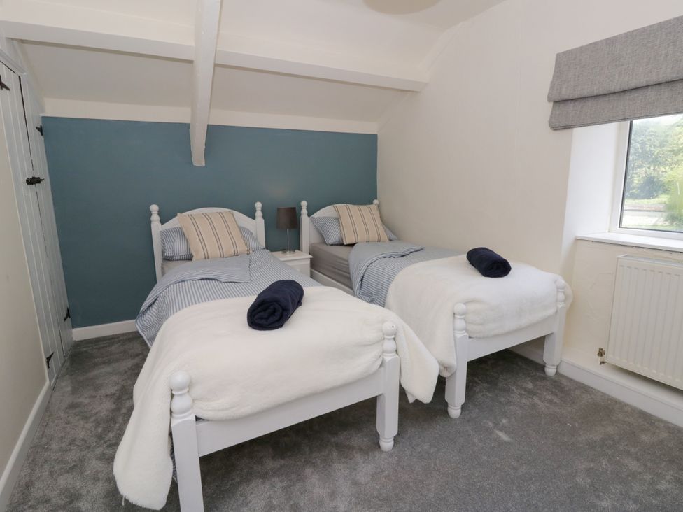 A bedroom with two beds and a window at The Cart House in Pontsian