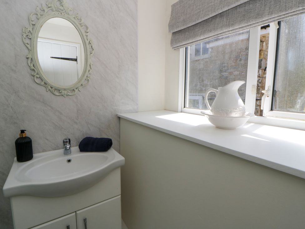 A bathroom with a sink and mirror at The Cart House in Pontsian