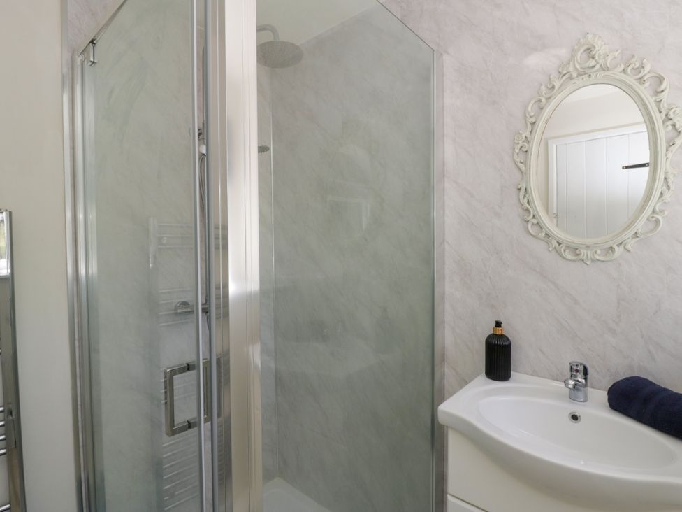 A bathroom with a shower and sink at The Cart House in Pontsian