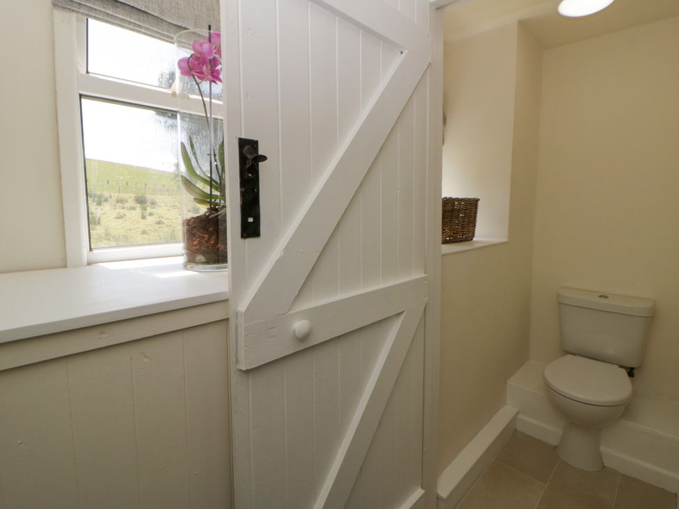 A bathroom with a toilet and plant at The Cart House in Pontsian
