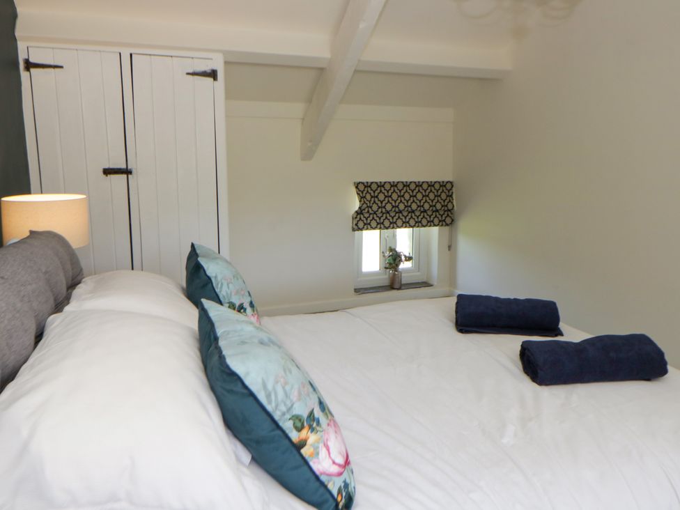 A bedroom with a bed and wardrobe at The Cart House in Pontsian