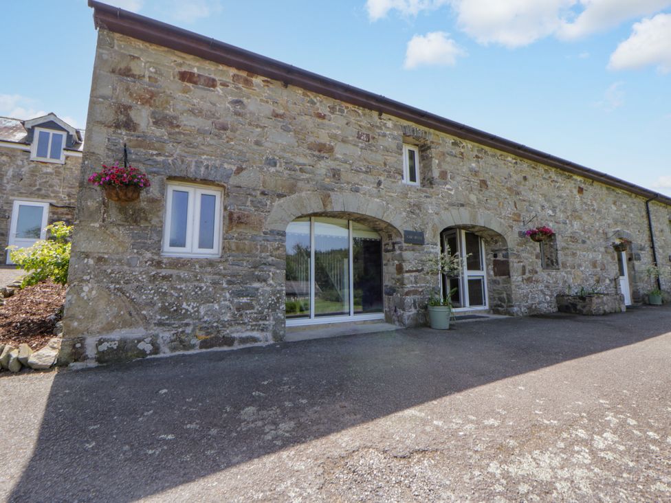 An exterior view of a stone building with windows and flower pots at The Cart House in Pontsian