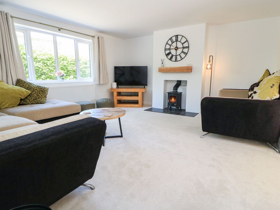 A living room with a fireplace and television at Cern-Wyn in Chippenham