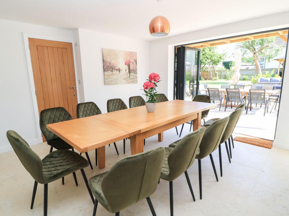 A dining room with a large table and chairs at Cern-Wyn in Chippenham