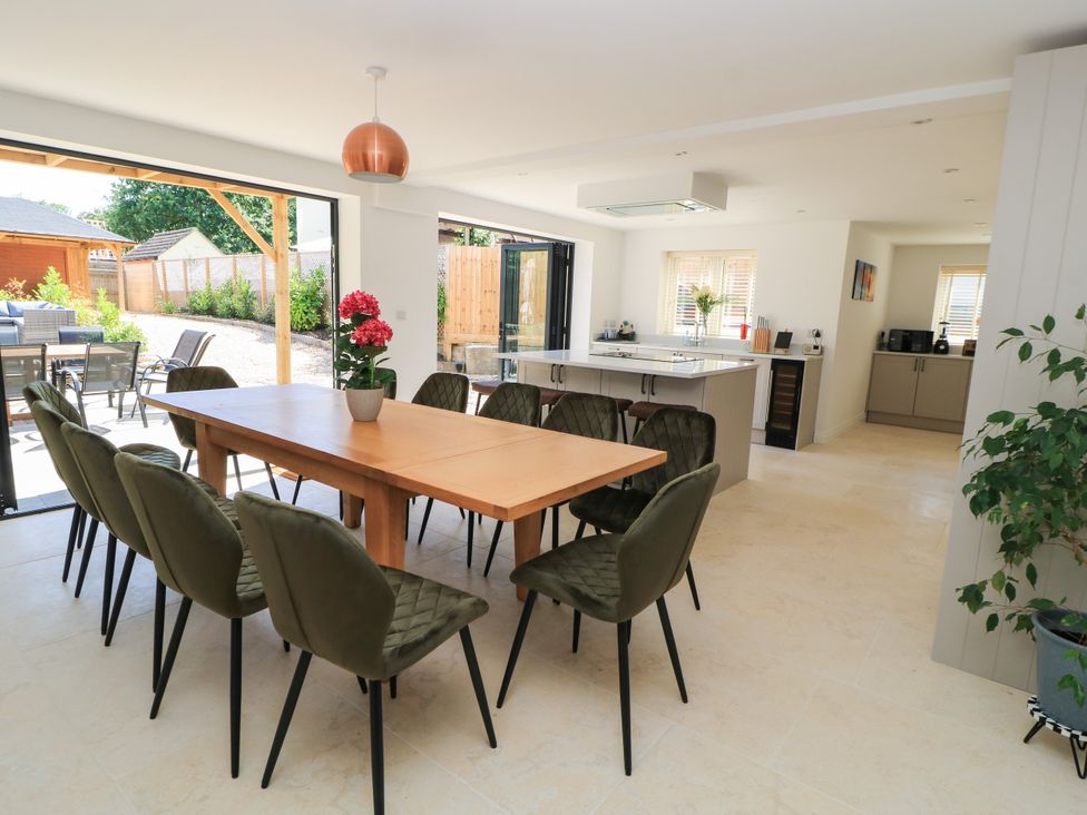 A dining area with a wooden table and chairs at Cern-Wyn in Chippenham