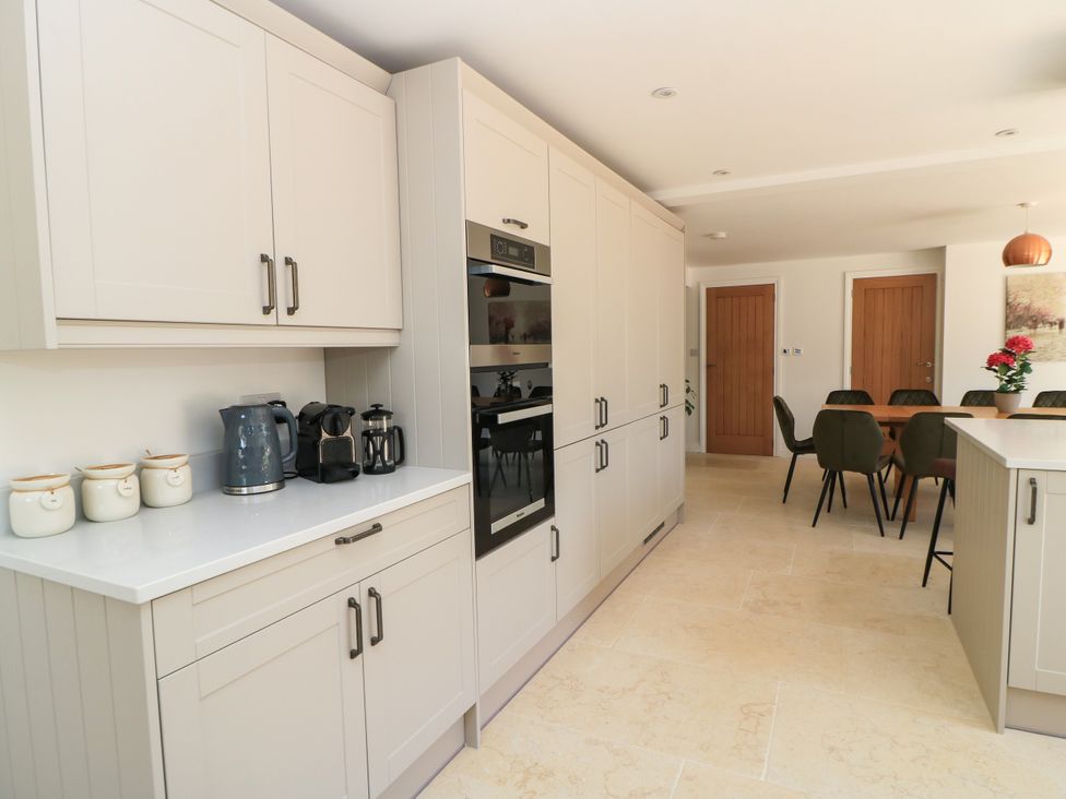 A kitchen with cabinets and appliances at Cern-Wyn in Chippenham