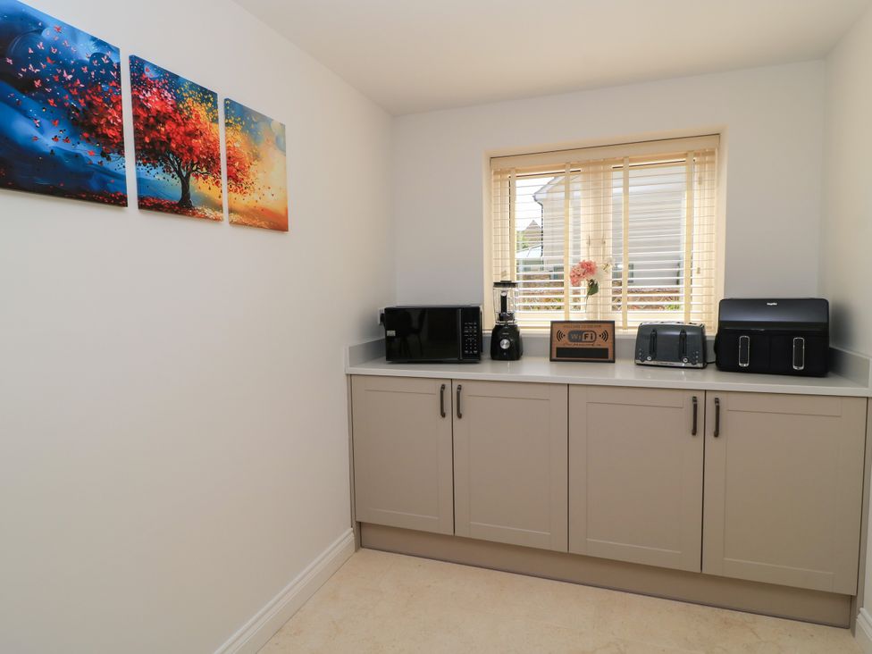 A kitchen with appliances and artwork at Cern-Wyn in Chippenham