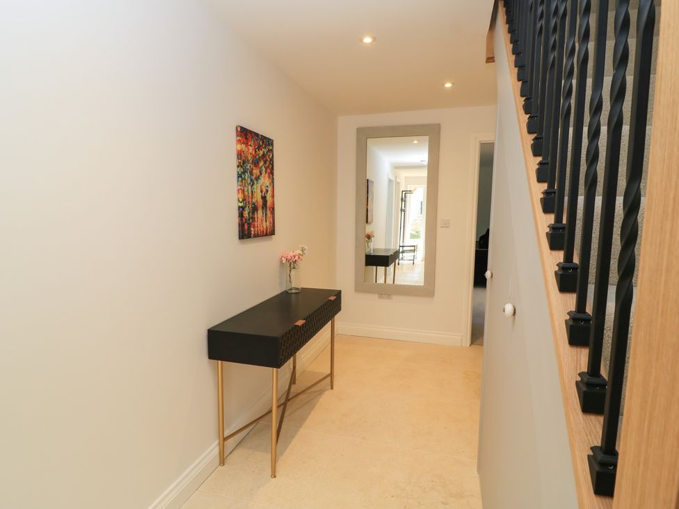 A hallway with a table and mirror at Cern-Wyn in Chippenham