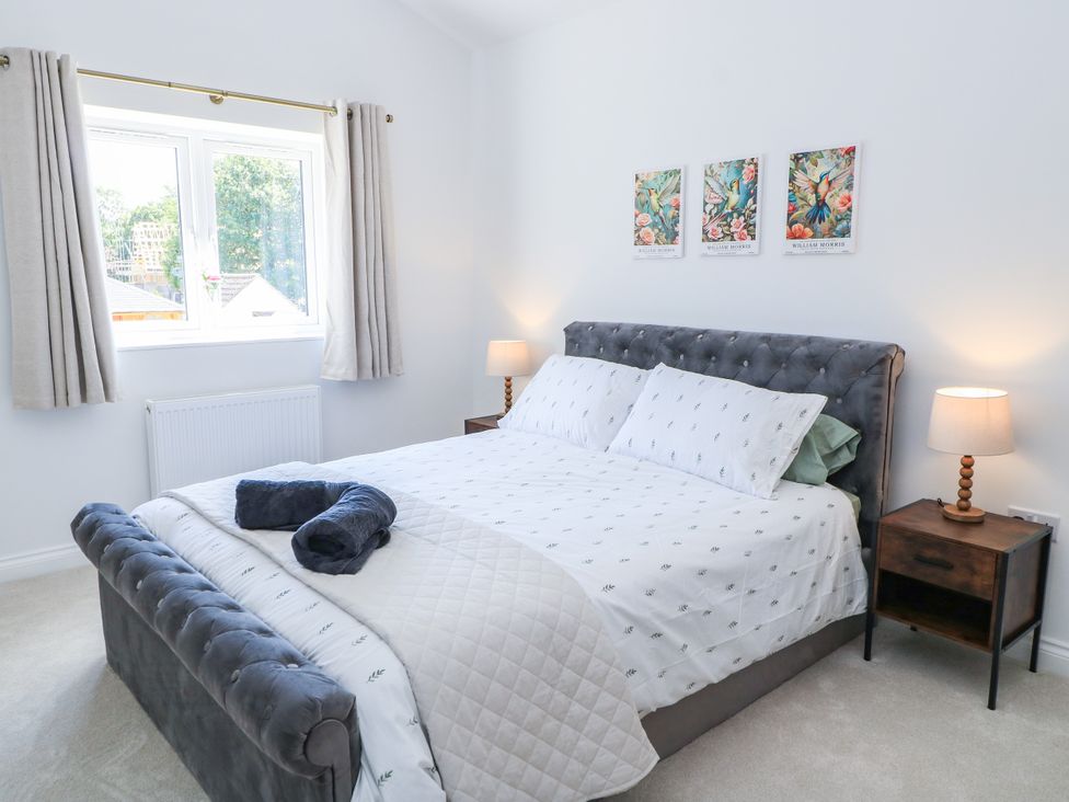 A bedroom with a bed and nightstand at Cern-Wyn in Chippenham