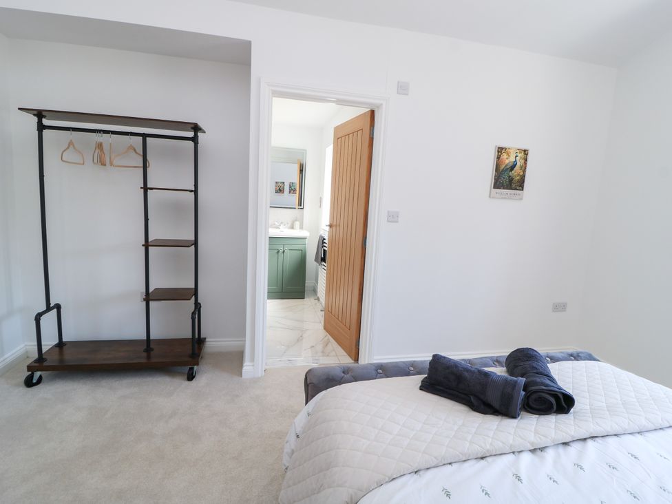 A bedroom with a bed and a shelf with hangers at Cern-Wyn in Chippenham
