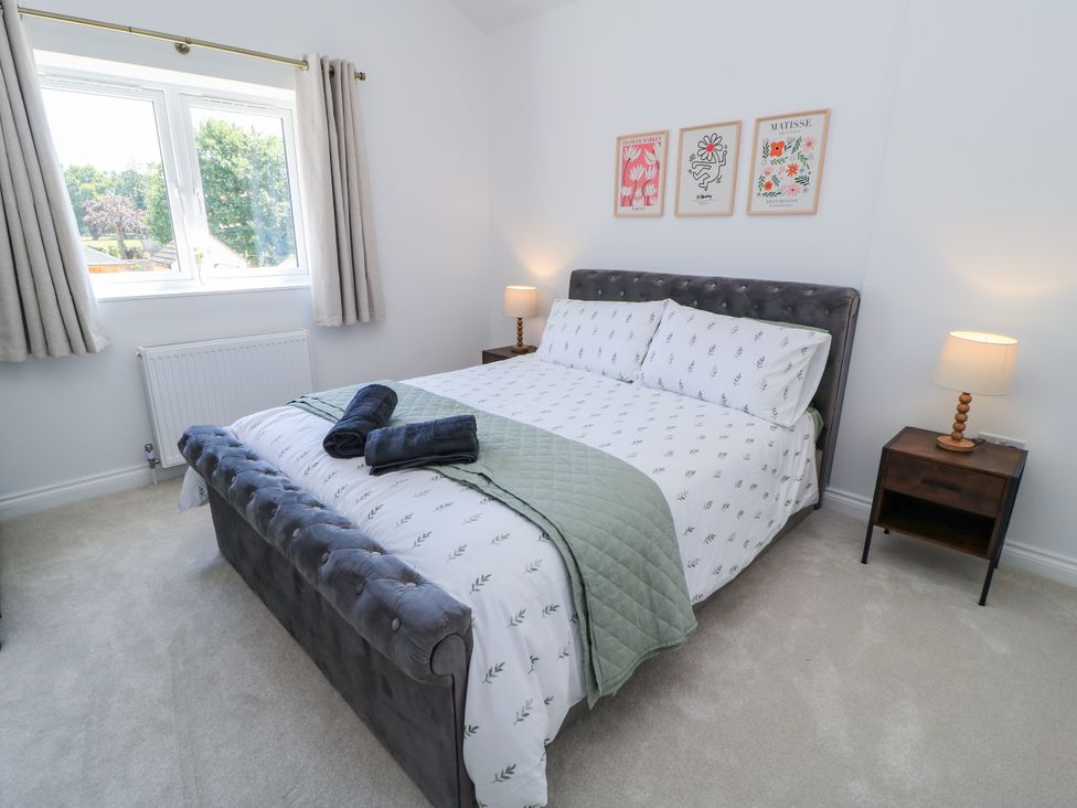 A bedroom with a bed and bedside table at Cern-Wyn in Chippenham