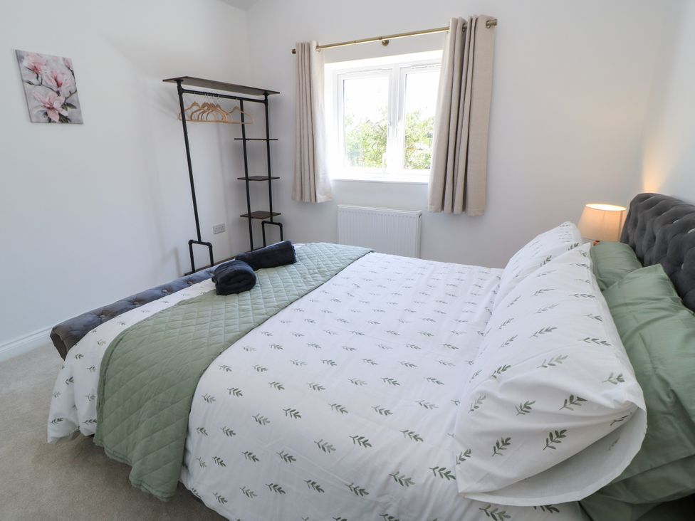 A bedroom with a bed and shelving unit at Cern-Wyn in Chippenham