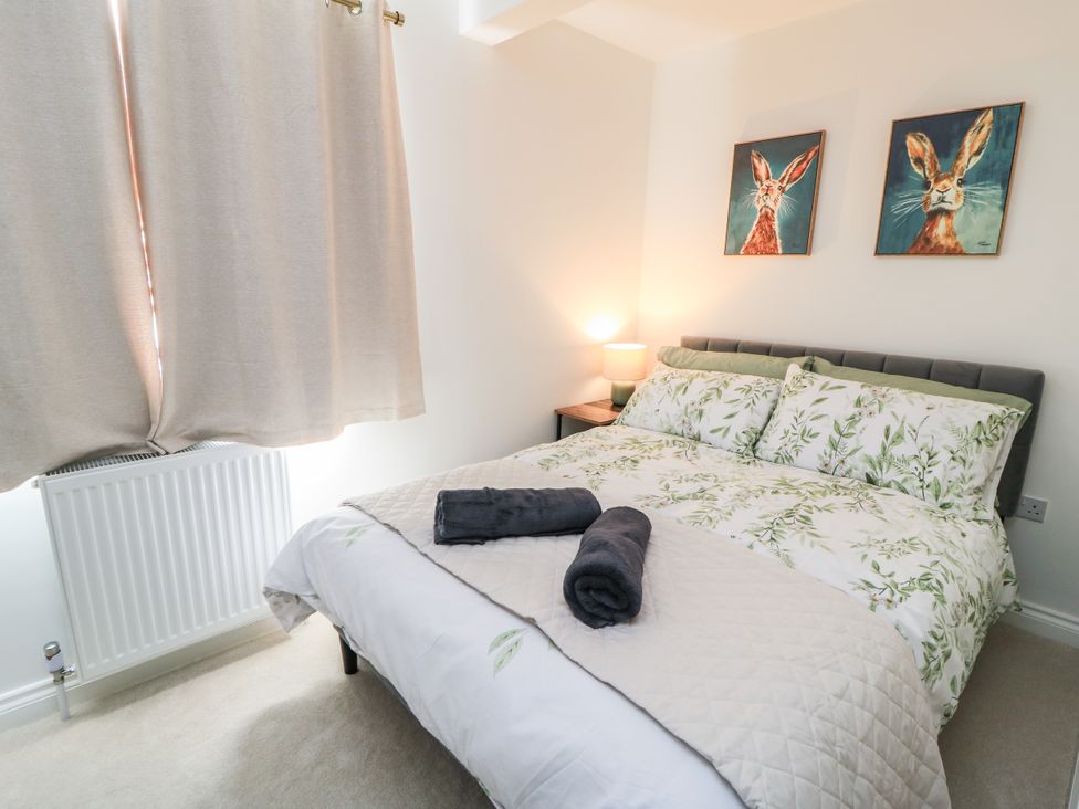 A bedroom with a bed and wall art at Cern-Wyn in Chippenham
