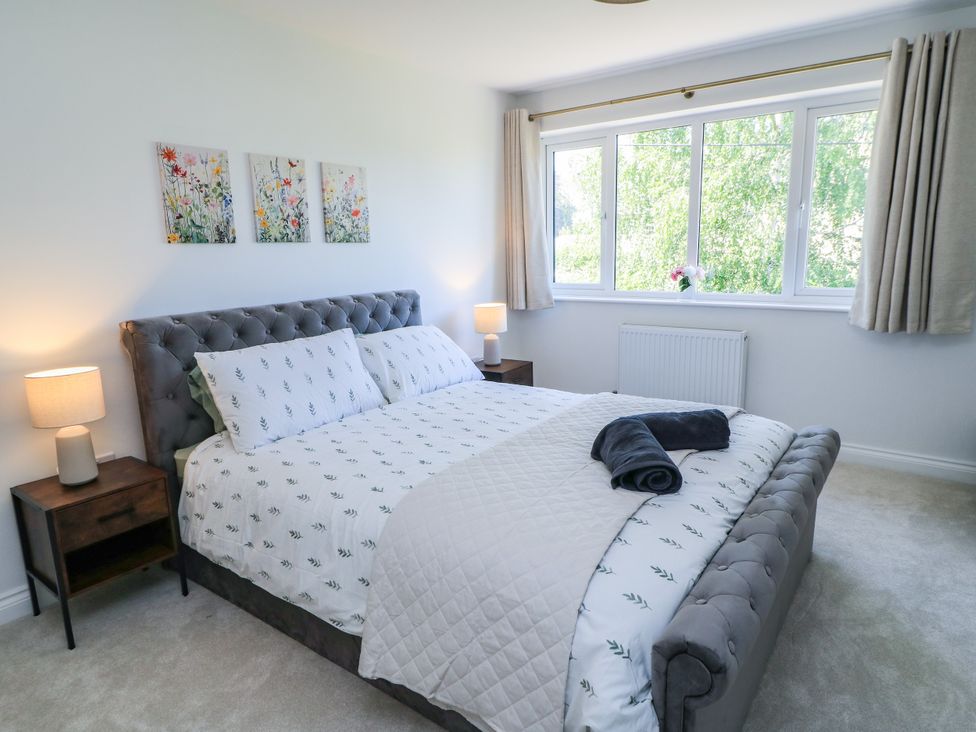 A bedroom with a bed and window at Cern-Wyn in Chippenham