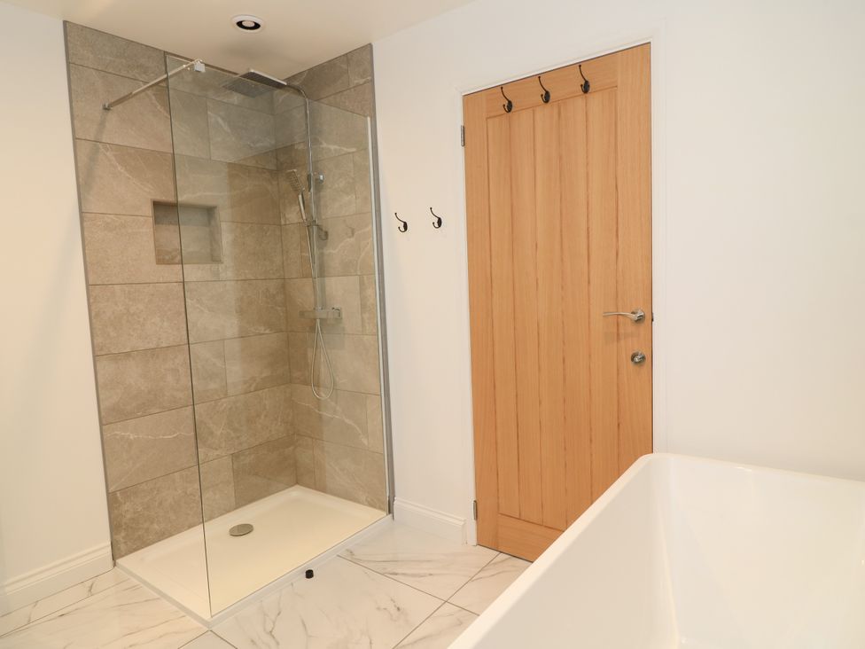 A bathroom with a shower and bathtub at Cern-Wyn in Chippenham