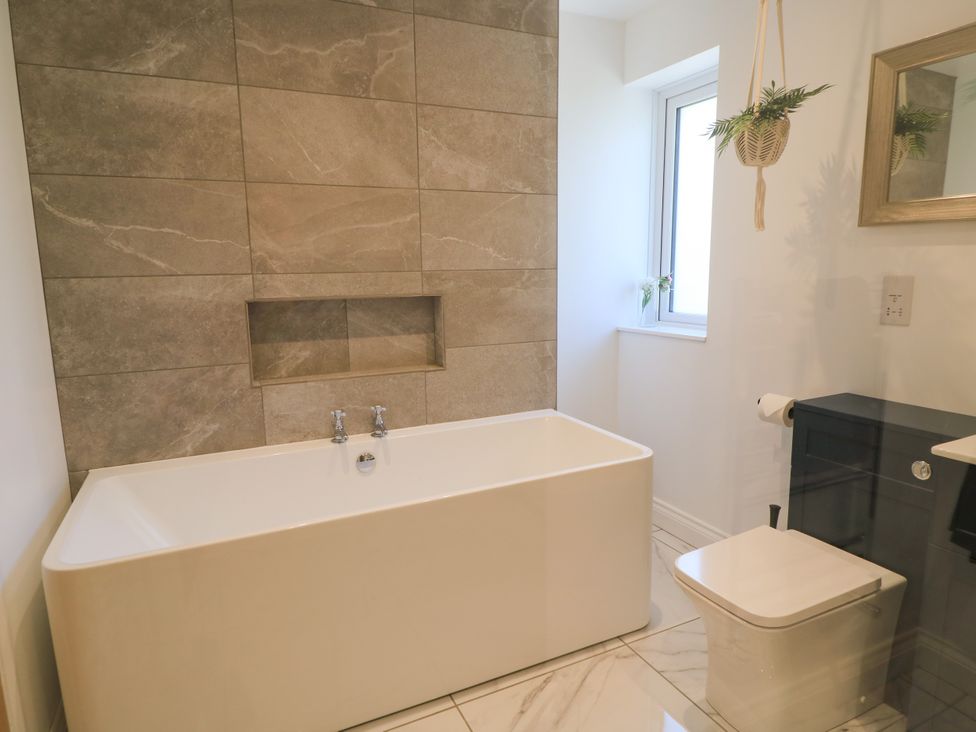A bathroom featuring a bathtub, toilet, and sink at Cern-Wyn in Chippenham