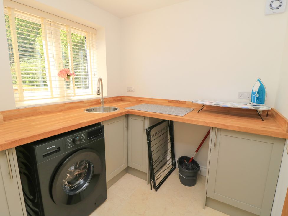 A utility room with a washing machine and sink at Cern-Wyn in Chippenham