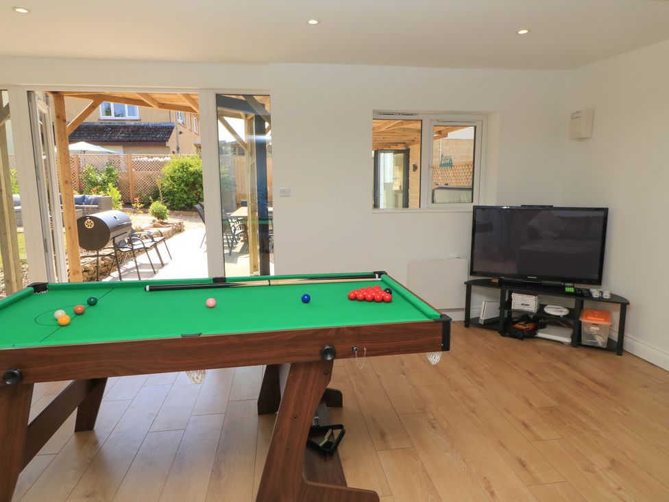 A game room with a pool table and television at Cern-Wyn in Chippenham