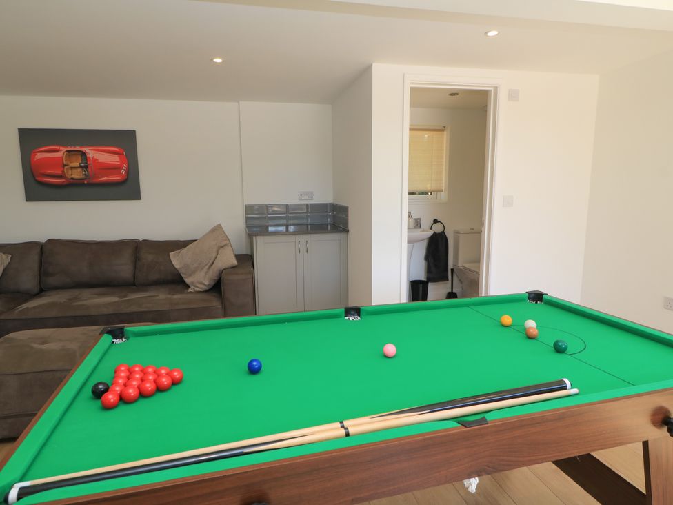 A game room with a pool table and sofa at Cern-Wyn in Chippenham
