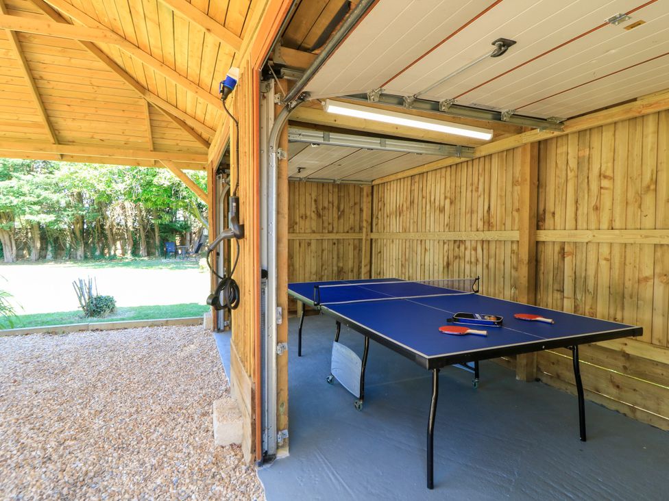 A table tennis table with paddles in a garage at Cern-Wyn in Chippenham