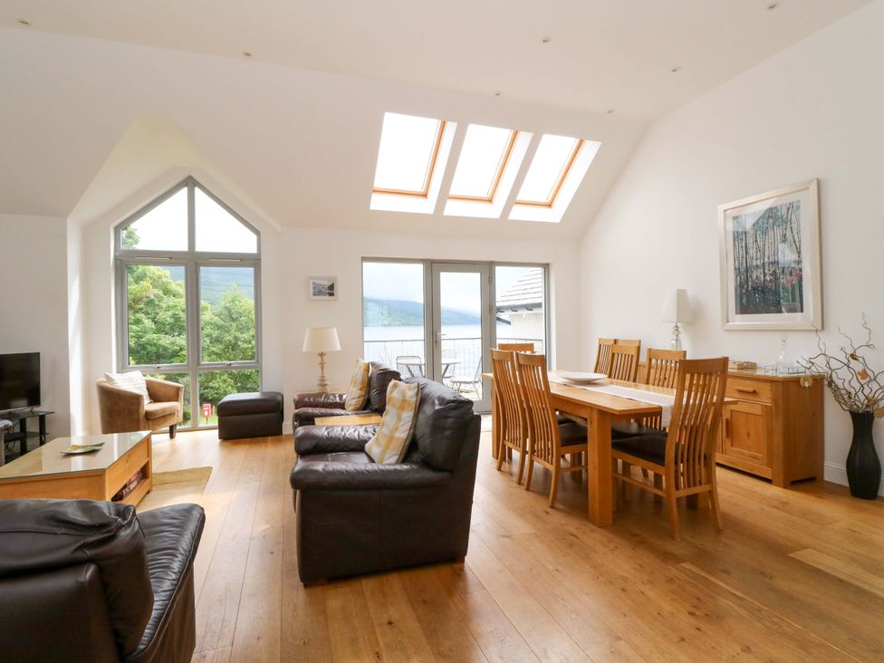 A living room with a television and dining table at Craigard in Aberfeldy