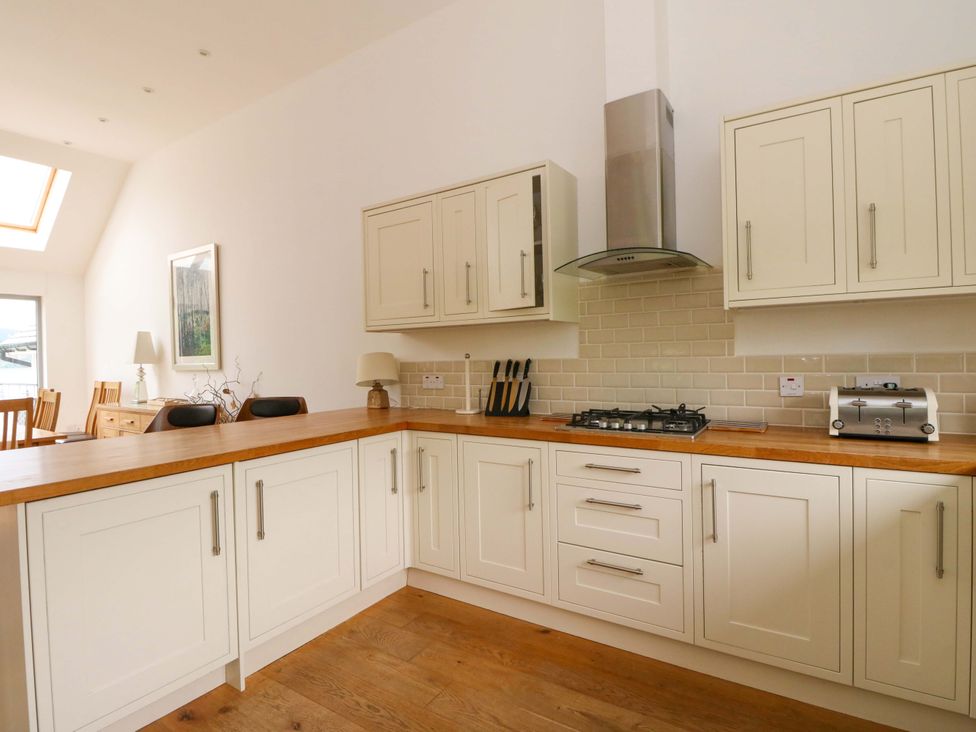 A kitchen with white cabinets and wooden countertop at Craigard in Aberfeldy