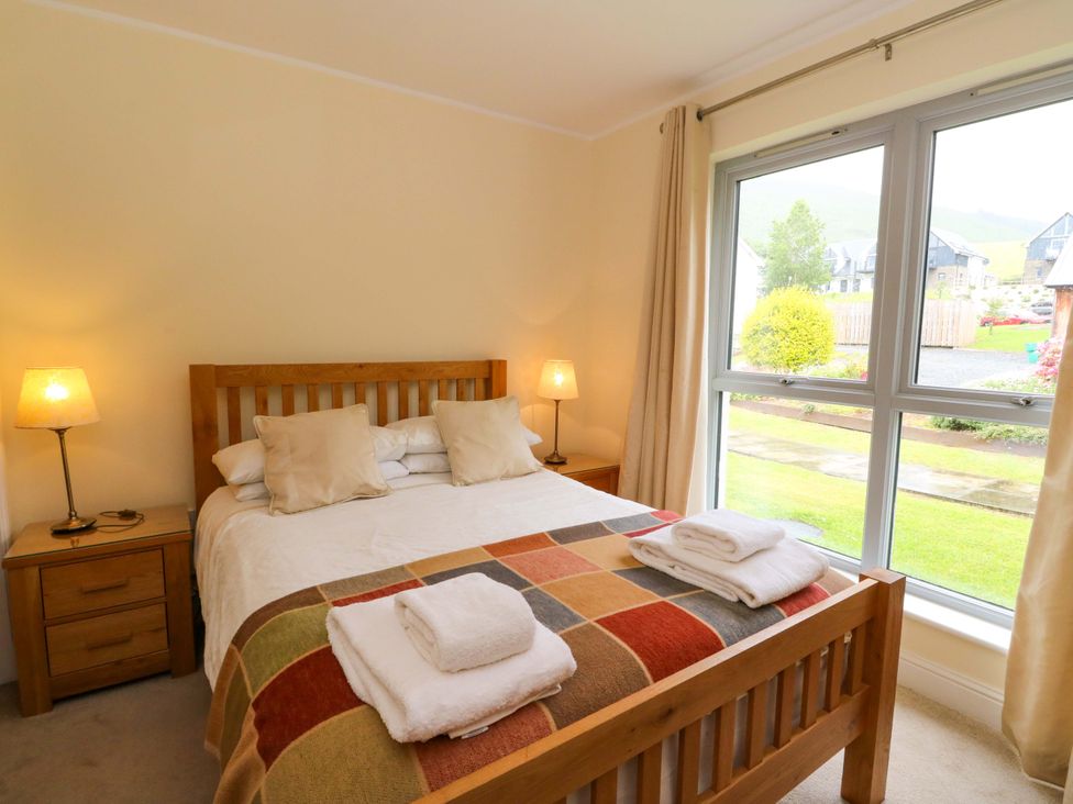 A bedroom with a bed and bedside tables at Craigard in Aberfeldy