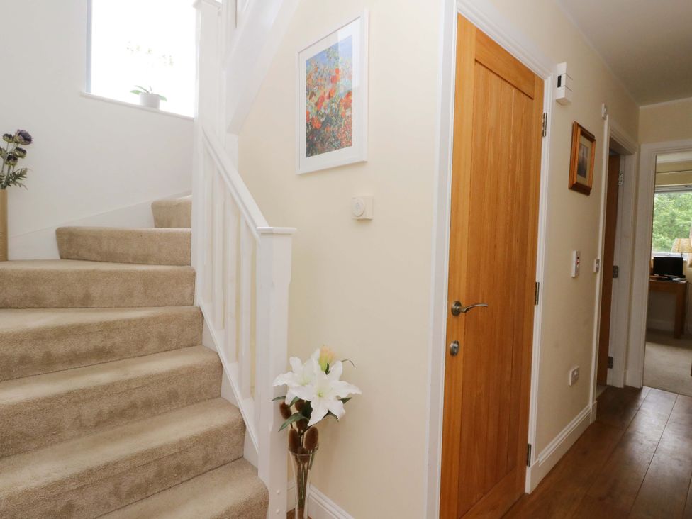 A hallway with stairs and a door at Craigard in Aberfeldy