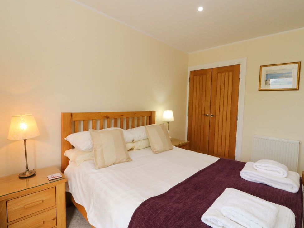 A bedroom with a double bed and bedside lamp at Craigard Aberfeldy