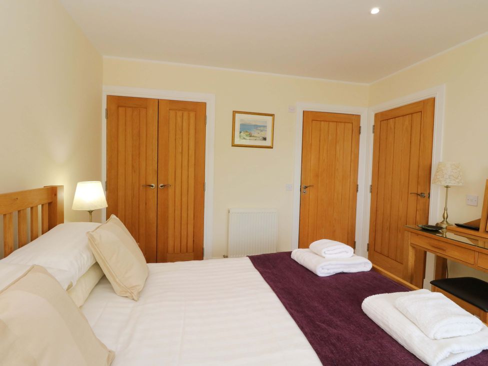 A bedroom with a bed and three doors at Craigard in Aberfeldy